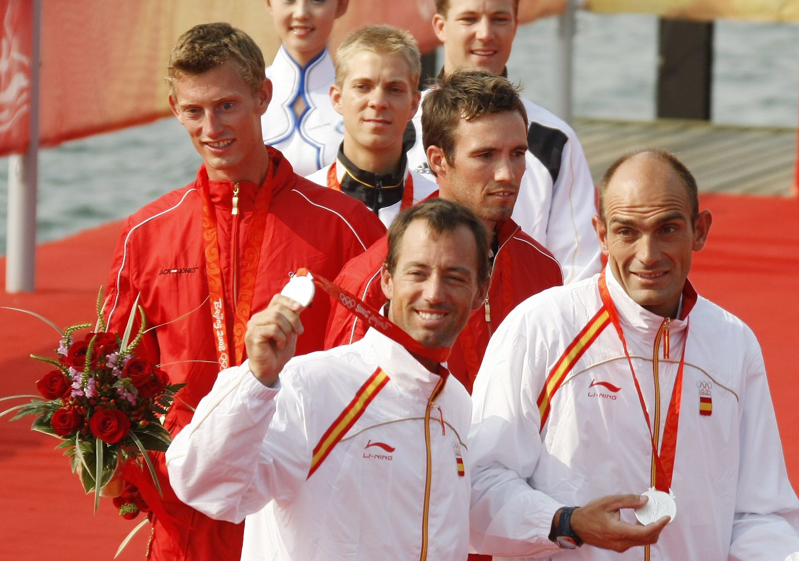 Iker Martínez y Xavi Fernández enseñan su medalla de plata en presencia de los daneses.