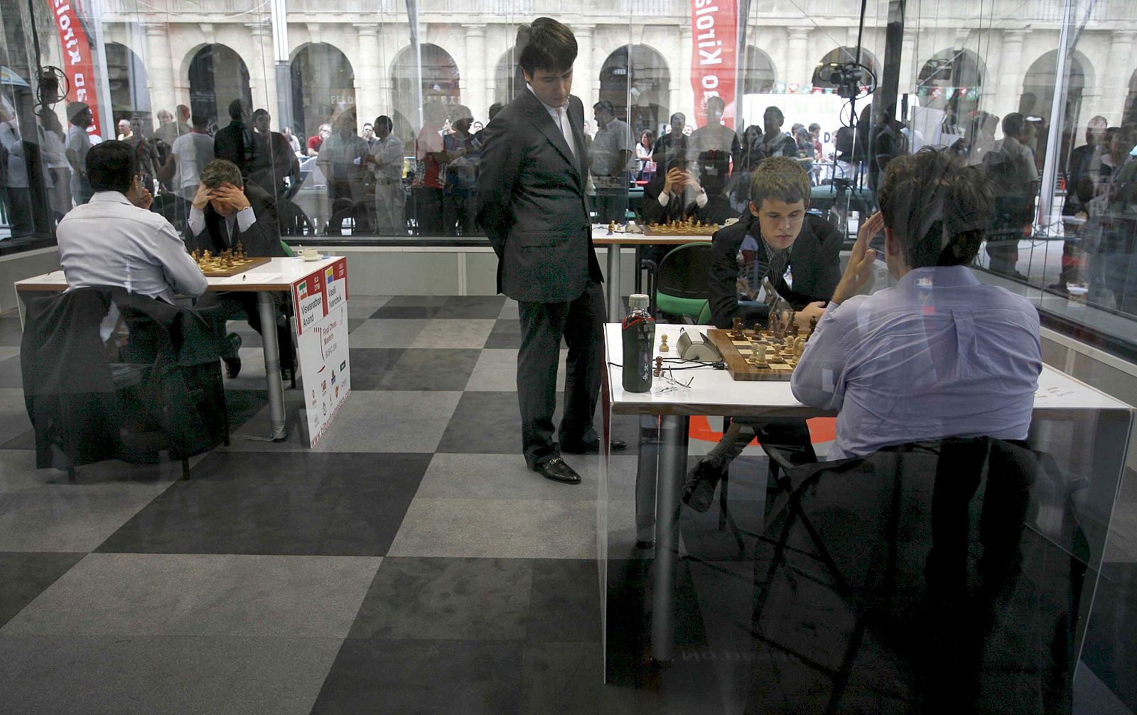 Varios maestros juegan la final del Gran Slam de Ajedrez en el interior de una urna de cristal instalada en la Plaza Nueva de Bilbao.