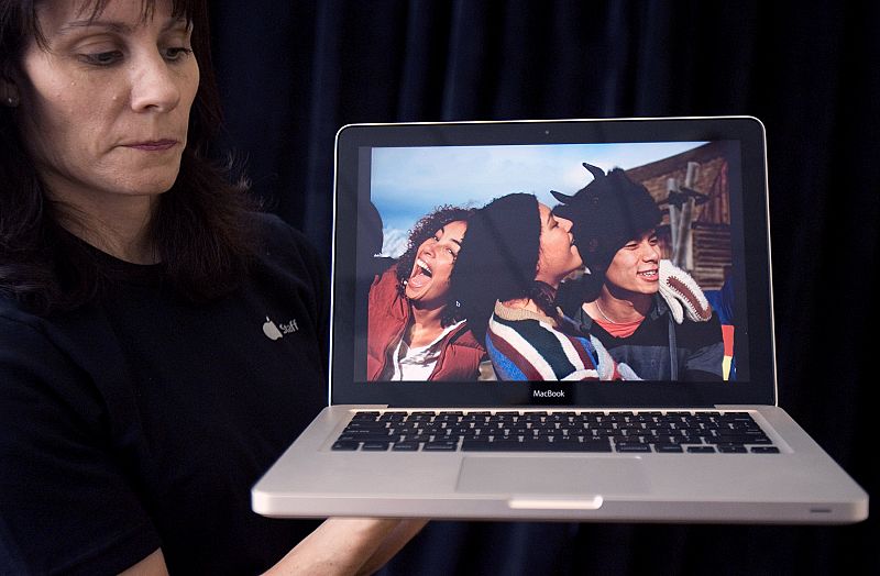 An Apple Inc. employee holds up the new MacBook at a news conference in Cupertino