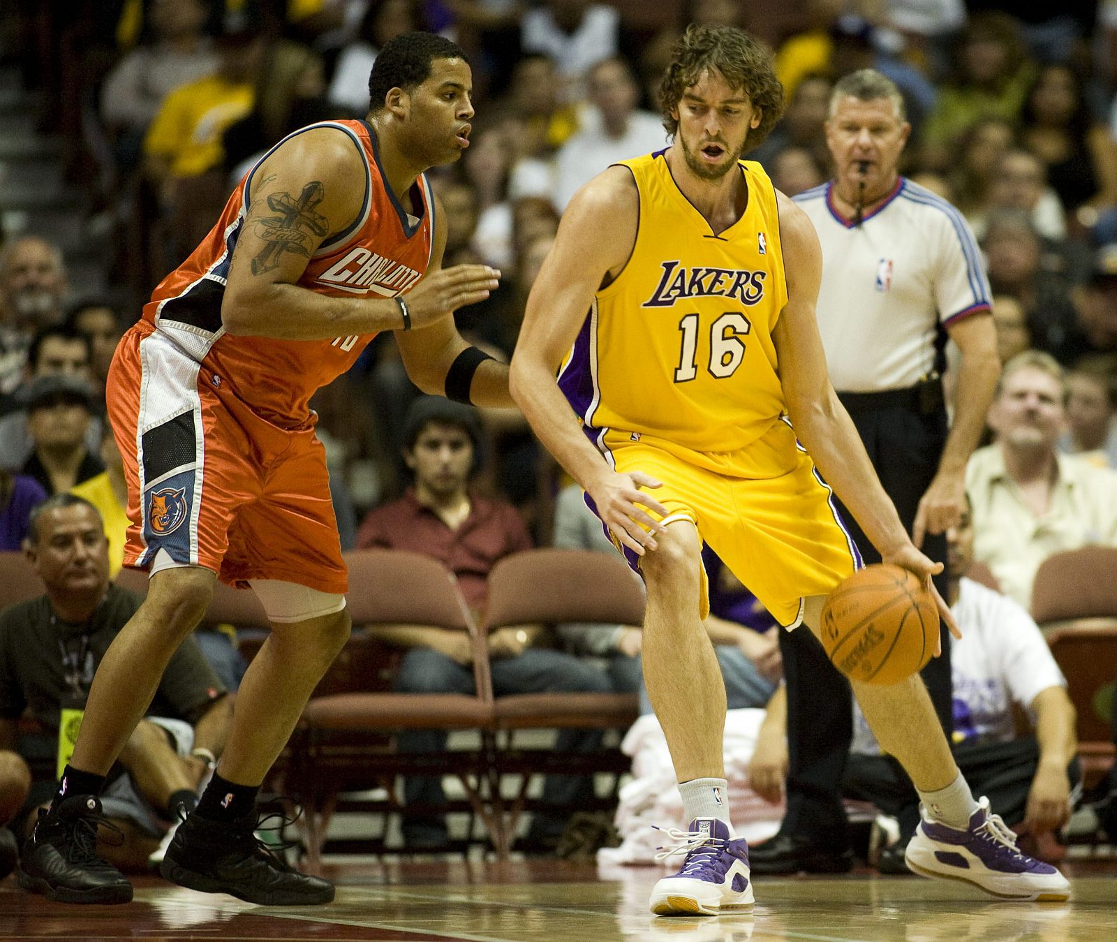 Pau Gasol, de los Lakers de Los Angeles, domina el balón con la marca de Sean May, de los Bobcats de Charlotte.