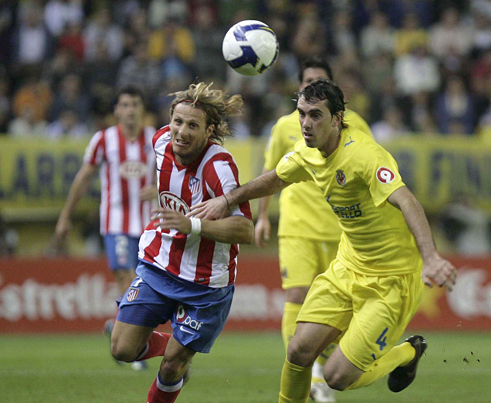El delantero uruguayo del Atlético de Madrid, Diego Forlán y el defensa del VIllarreal, Diego Roberto Godín luchan por el balón.