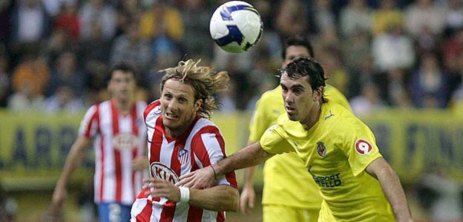 El delantero uruguayo del Atlético de Madrid, Diego Forlán y el defensa del VIllarreal, Diego Roberto Godín luchan por el balón.