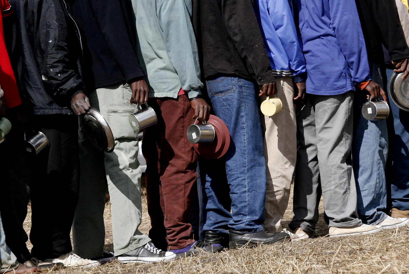 Un grupo de desplazados africanos espera su ración de comida.