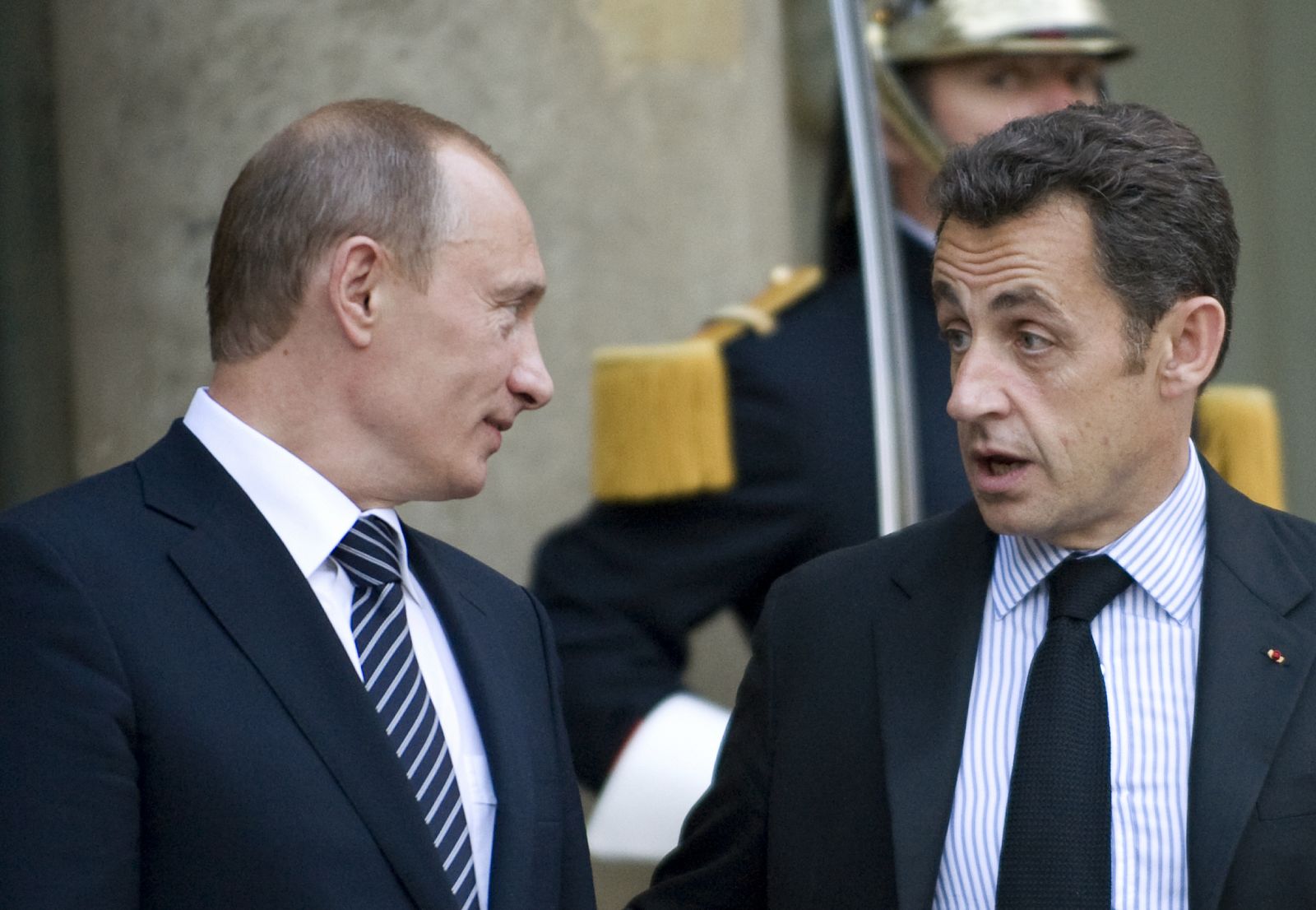 France's President Sarkozy speaks with Russia's Prime Minister Putin in Paris