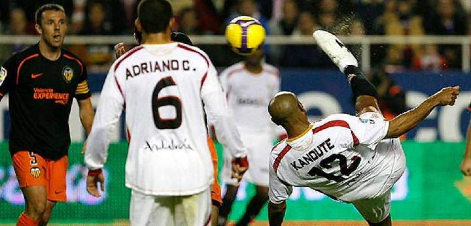 El delentero del Sevilla Kanouté remata a puerta ante su compañero Adriano y el jugador del Valencia Marchena.
