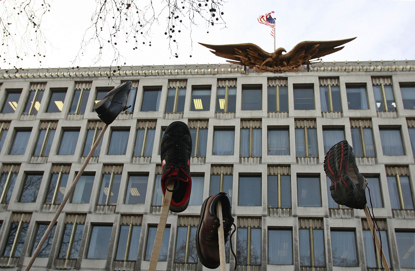 Un grupo de manifestantes ondean zapatos como banderas en la embajada de EE.UU. en Londres.