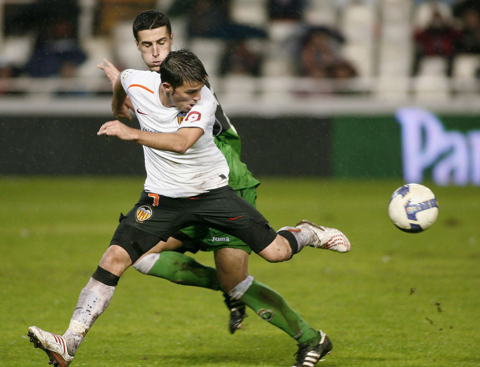 El valencianista David Villa lucha junto al jugador del Racing, Ivan Marcano, por el control de la pelota.