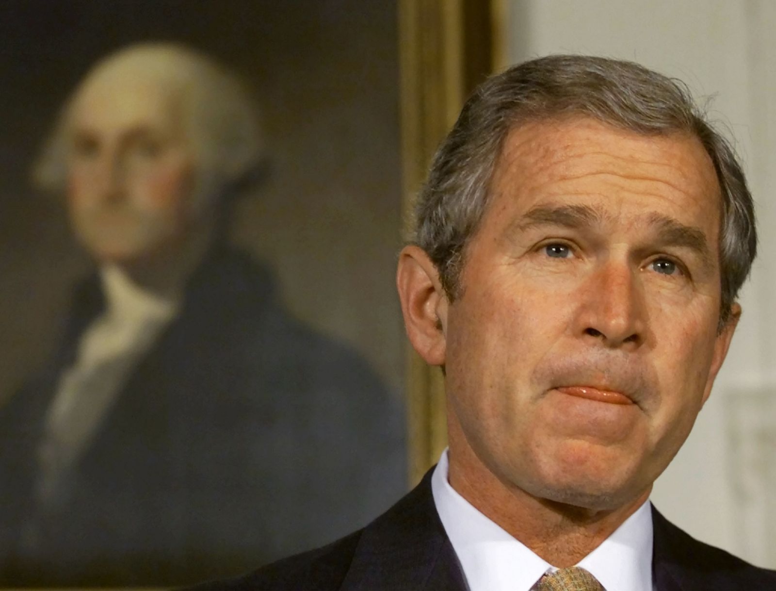 George W. Bush posa con el retrato de George Washington en la Casa Blanca