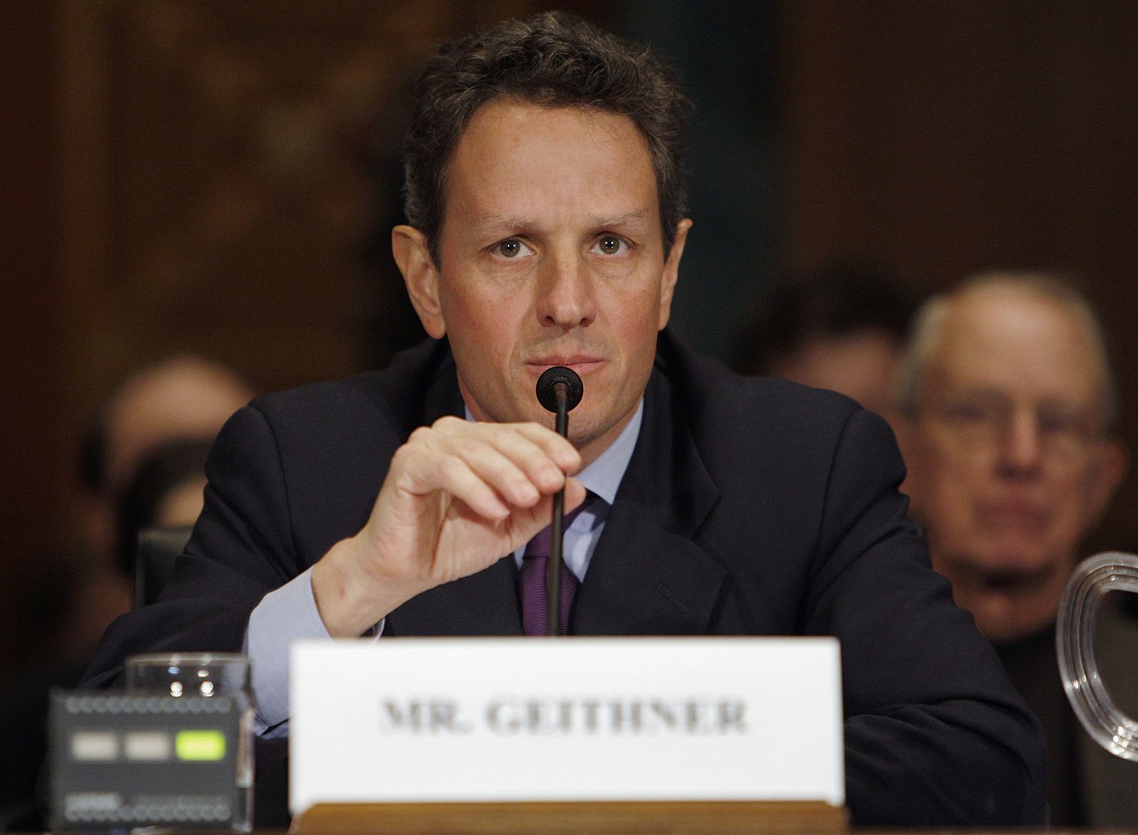 Geithner adjusts his microphone during his confirmation hearing before the Senate Finance Committee on Capitol Hill in Washington