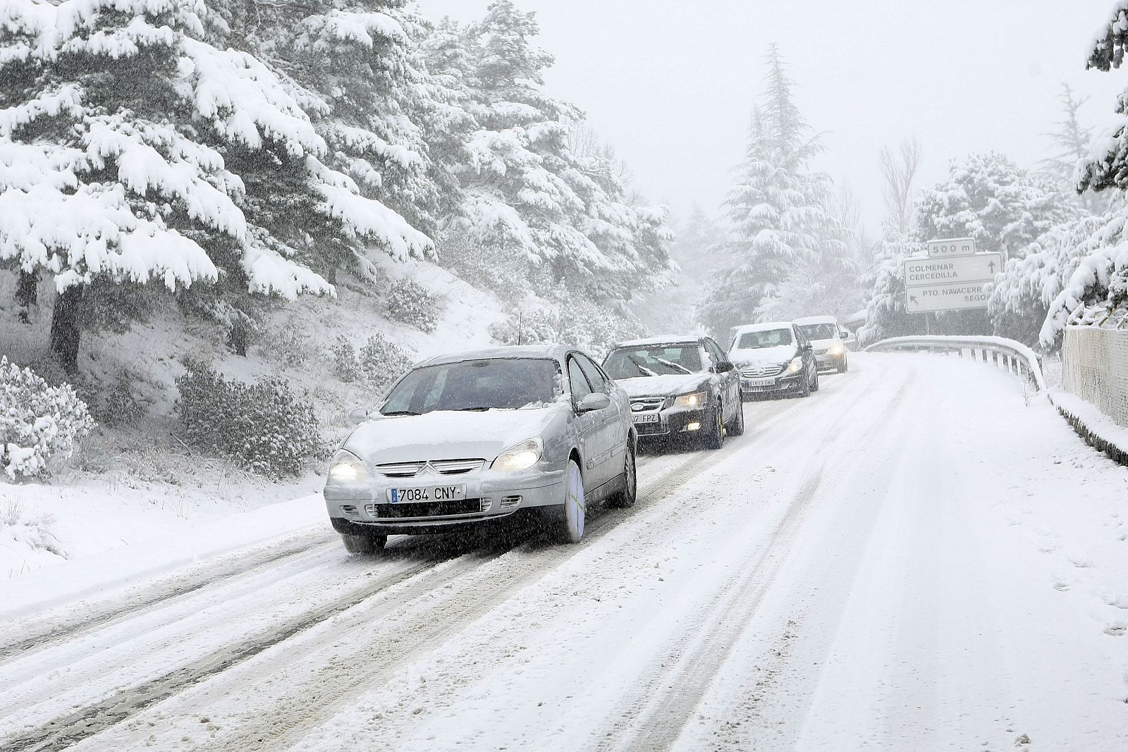 Un grupo de coches regresa del puerto de Navacerrada en Madrid, comunidad afectada por el fuerte temporal de nieve.