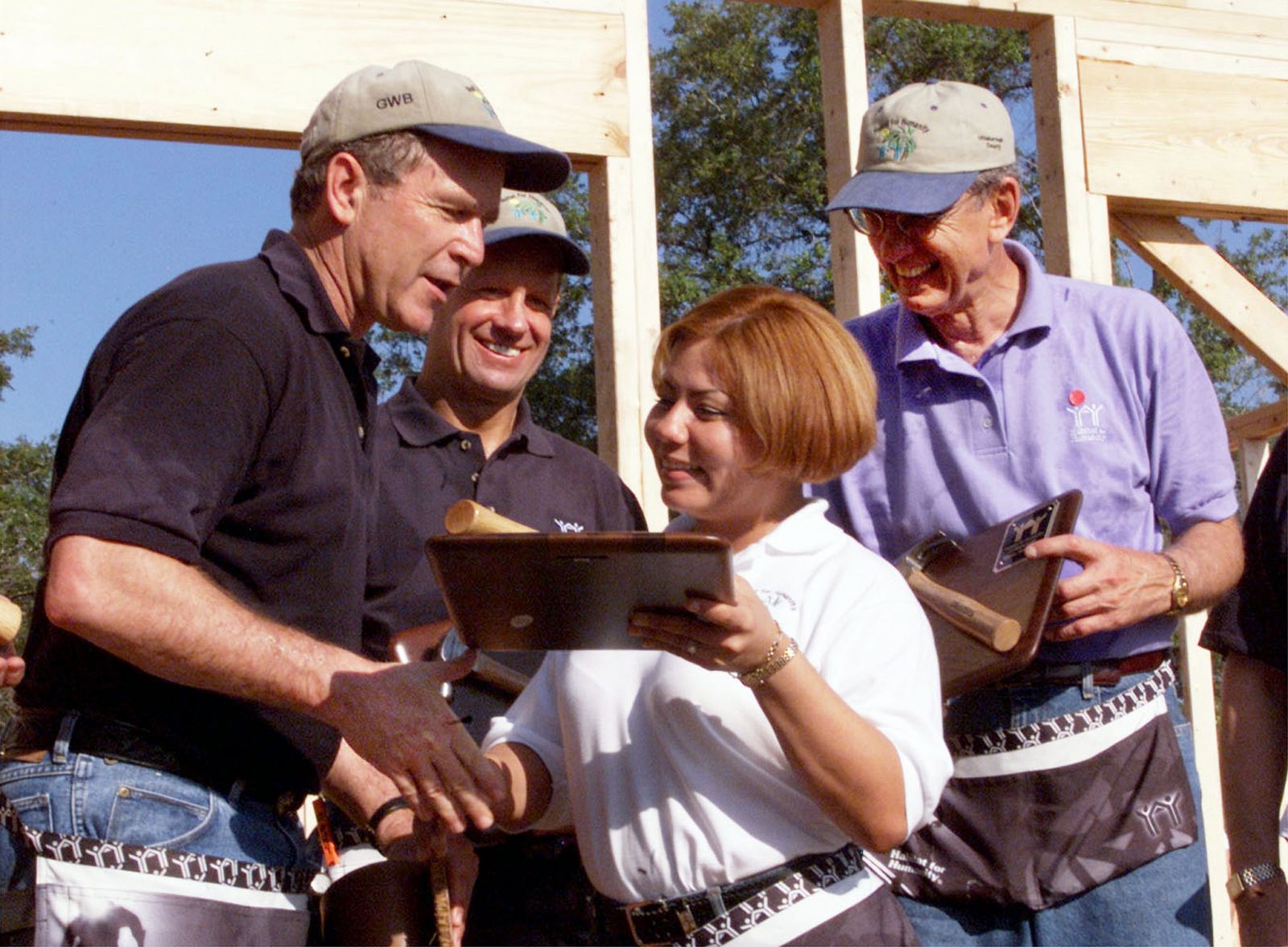 George W. Bush recibe una placa después de que participara en la construcción de una de las casas de Fuller (detrás a la derecha), en Tampa.