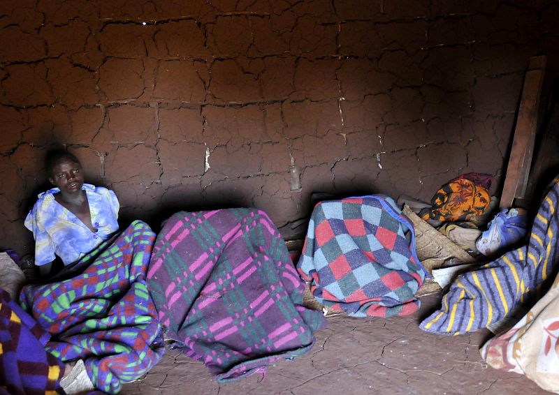 A teenager from Uganda's Sebei tribe sits inside a mud hut after undergoing female genital mutilation in Bukwa district