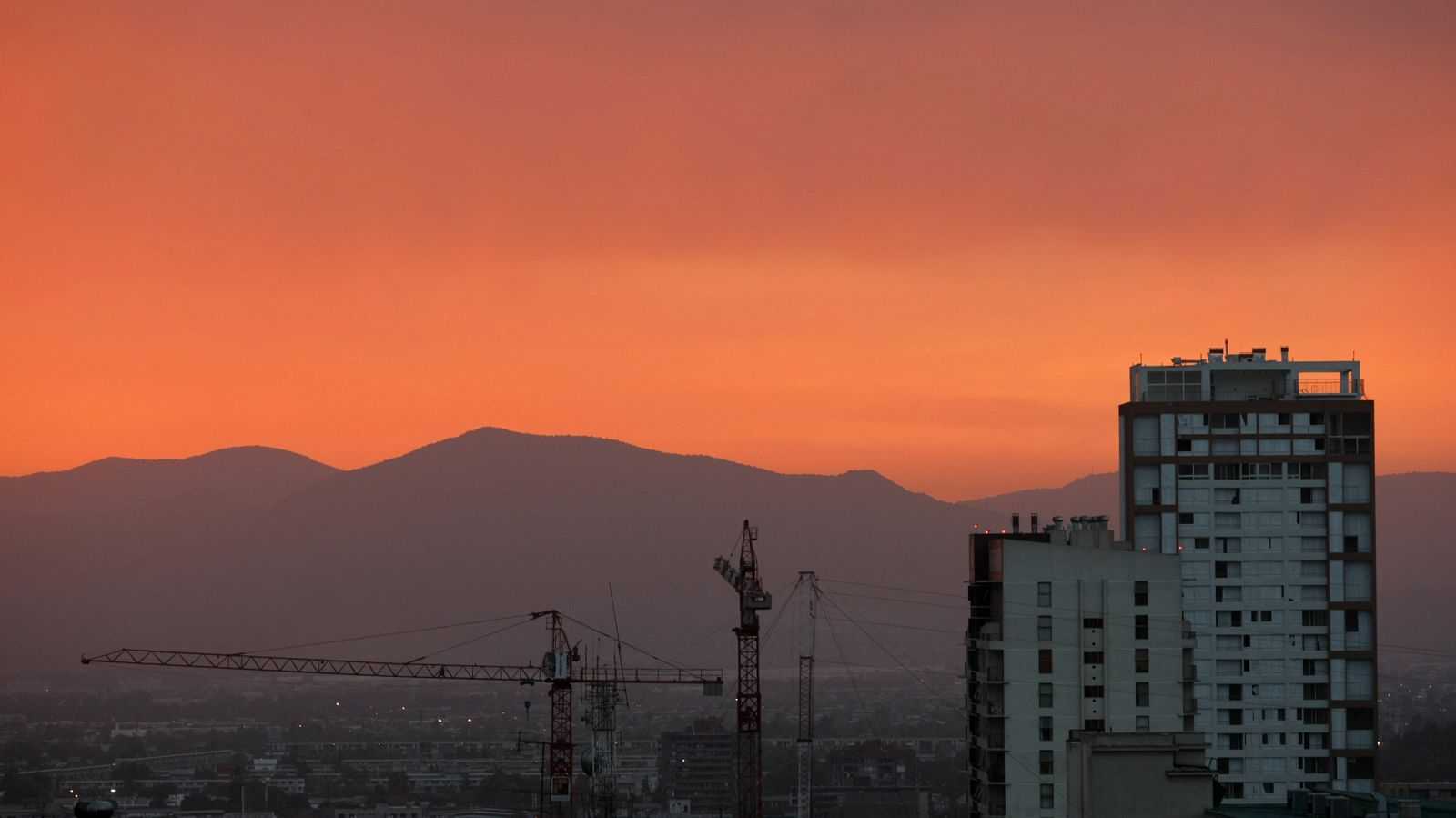 Algunas grúas junto a un edificio de apartamentos.