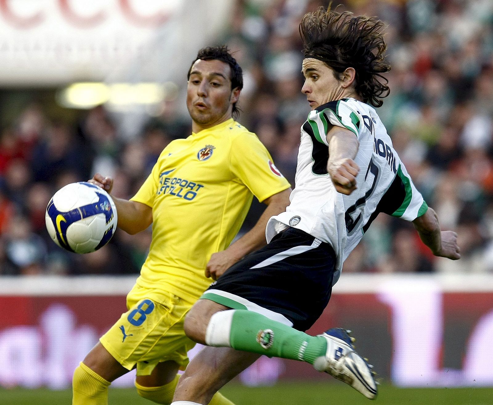 El centrocampista del Racing de Santander Antonio Moral se dispone a lanzar a puerta ante la oposición del Santiago Cazorla del Villarreal.