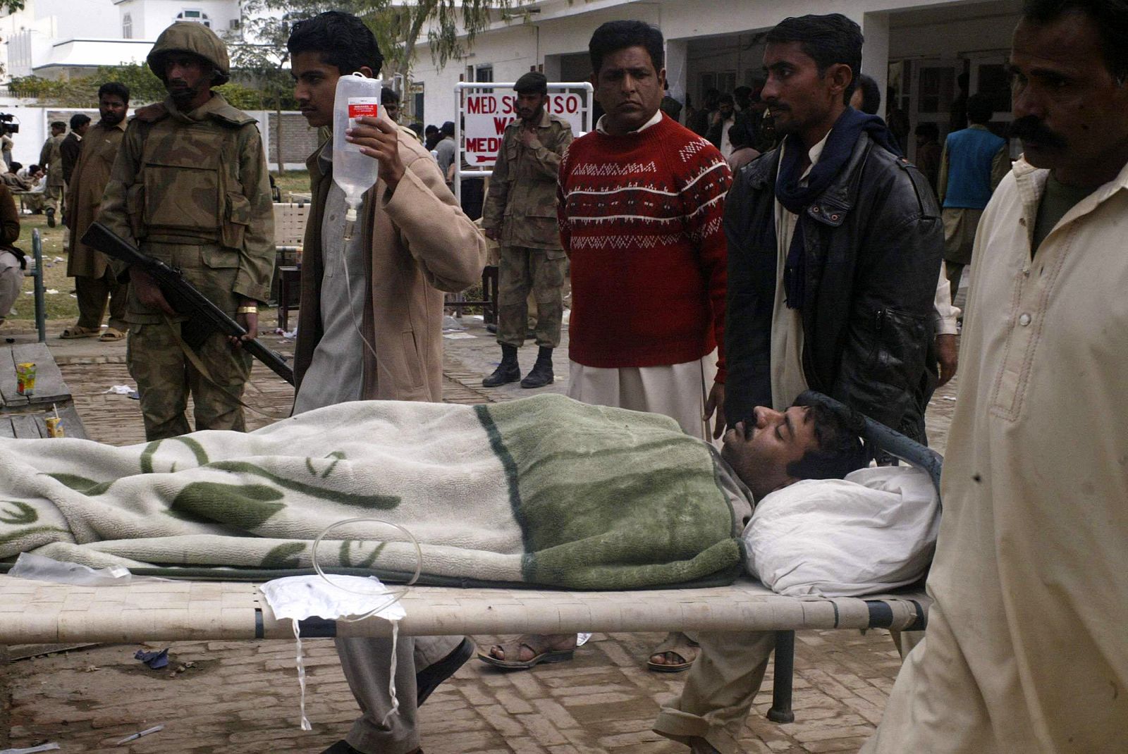 Relatives carry an injured of a bomb blast in a military hospital in Dera Ismail Khan