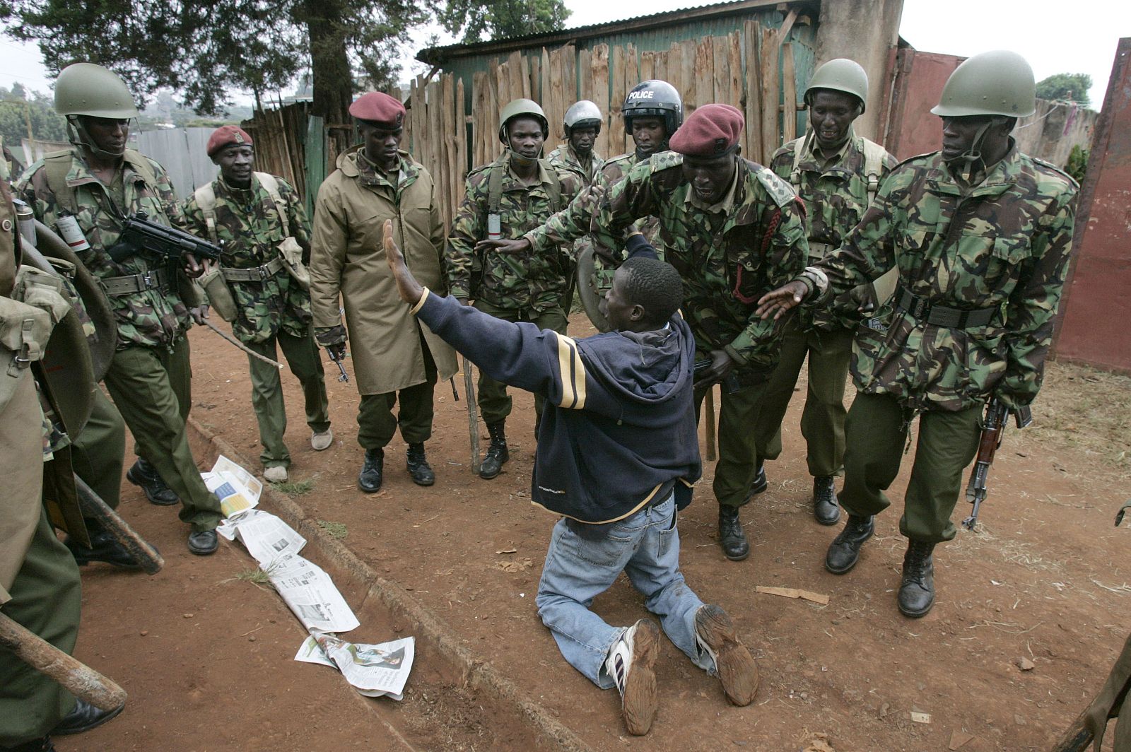 Un ciudadano pide la misericordia de policías antidisturbios durante las protestas en los barrios de Kibera en Nairobi.