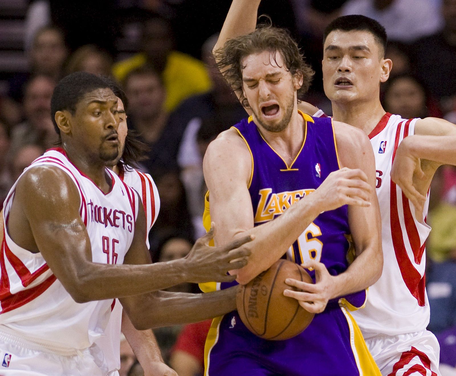 Pau Gasol (C) disputa la bola con Ron Artest (i) y el chino Yao Ming (d), de los Rockets de Houston.