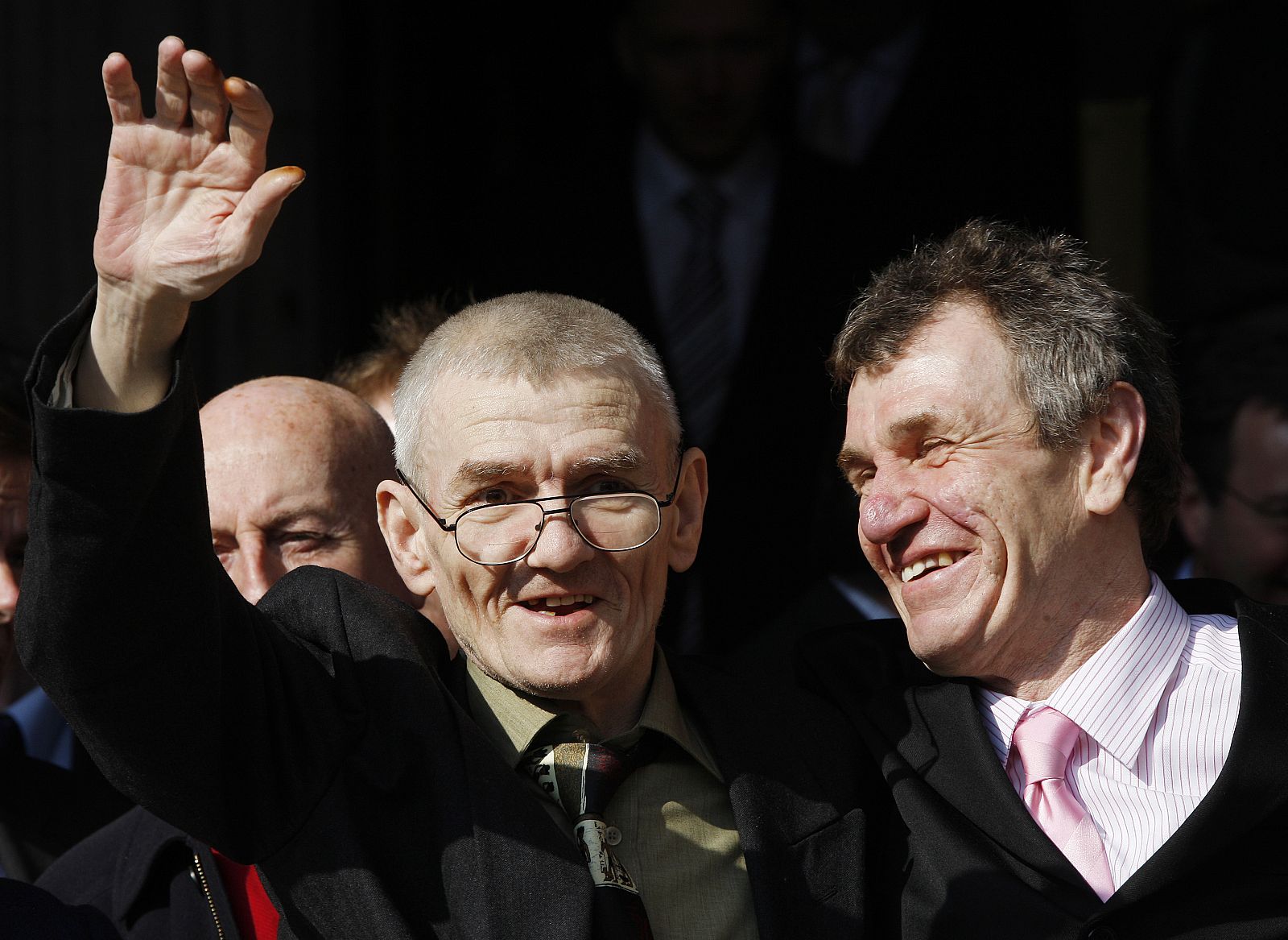 Sean Hodgson waves as he stands with his brother Peter outside the High Court in London