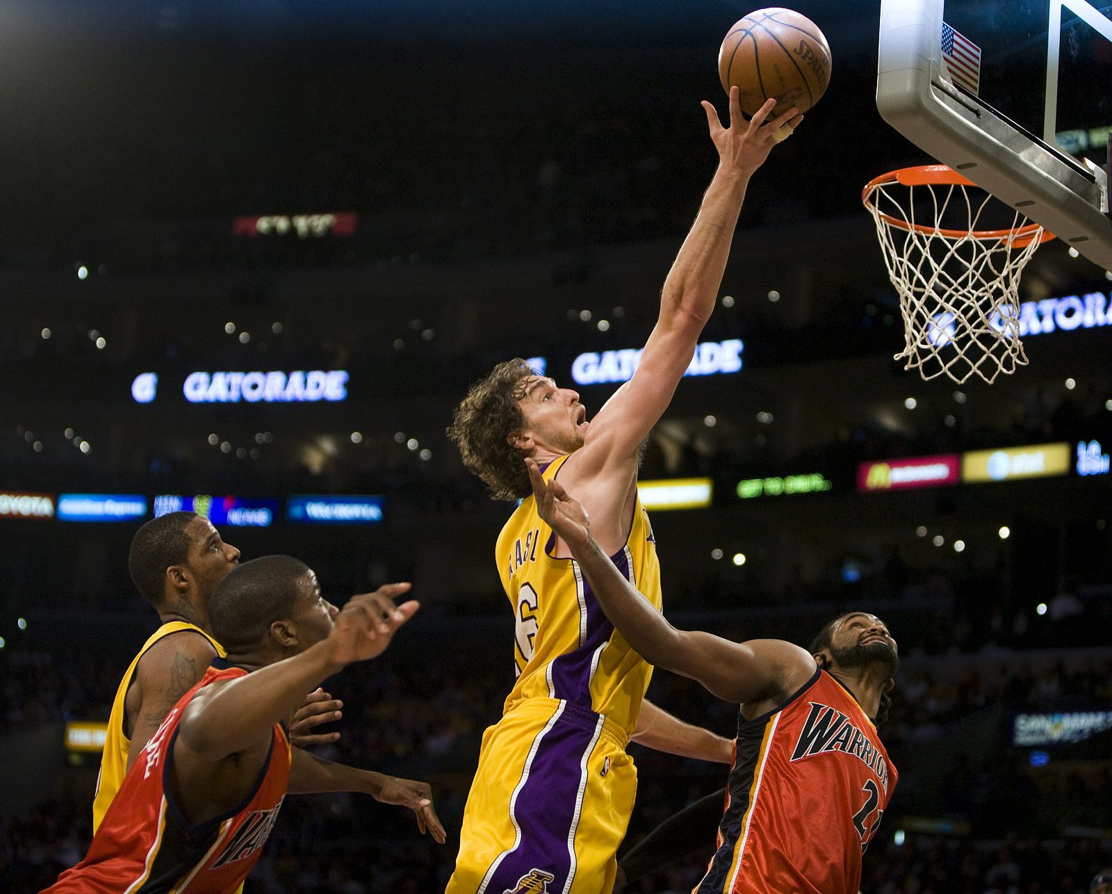 Pau Gasol se dirige hacia la cesta con la marca de Ronny Turiaf de los Warriors.