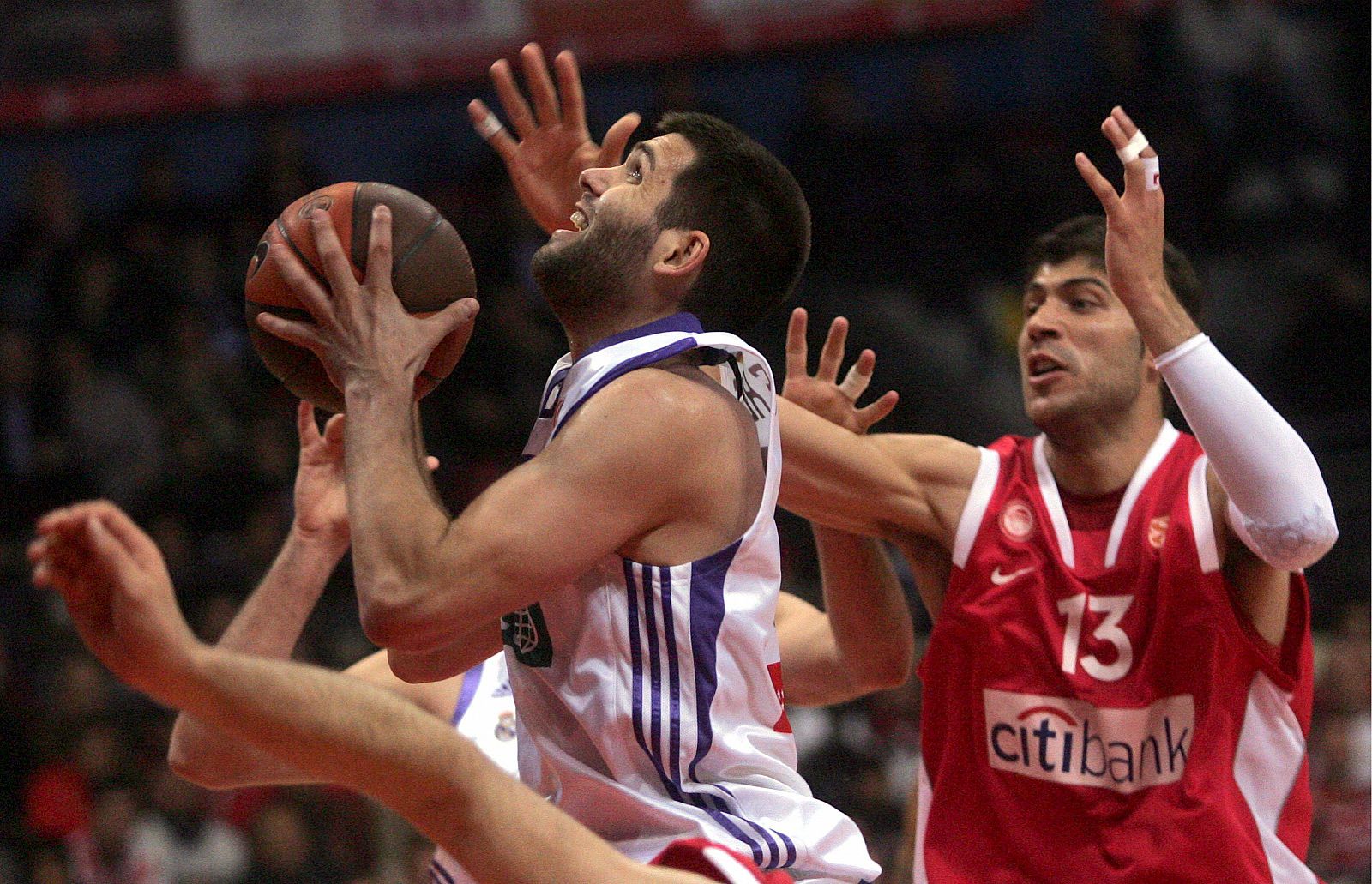 El jugador del Olympiacos Vasilopoulos pelea por el balón con el jugador del Real Madrid Felipe Reyes.
