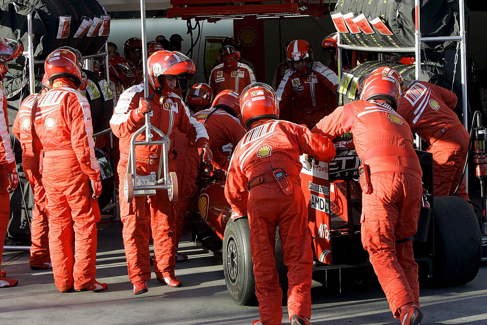 Los mecánicos de la escudería Ferrari introducen en su garaje el monoplaza del piloto brasileño Felipe Massa.