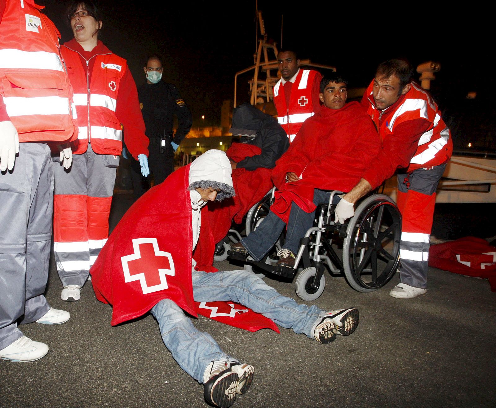 Efectivos de Cruz Roja socorren a varios inmigrantes que viajaban en una de las pateras que Salvamento Marítimo ha rescatado este lunes cerca de la costa de Almería (06/04/09)