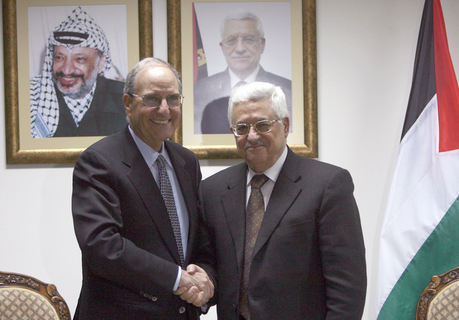 U.S. President Barack Obama's Middle East envoy Mitchell shakes hands with Palestinian President Abbas during their meeting in West Bank city of Ramallah