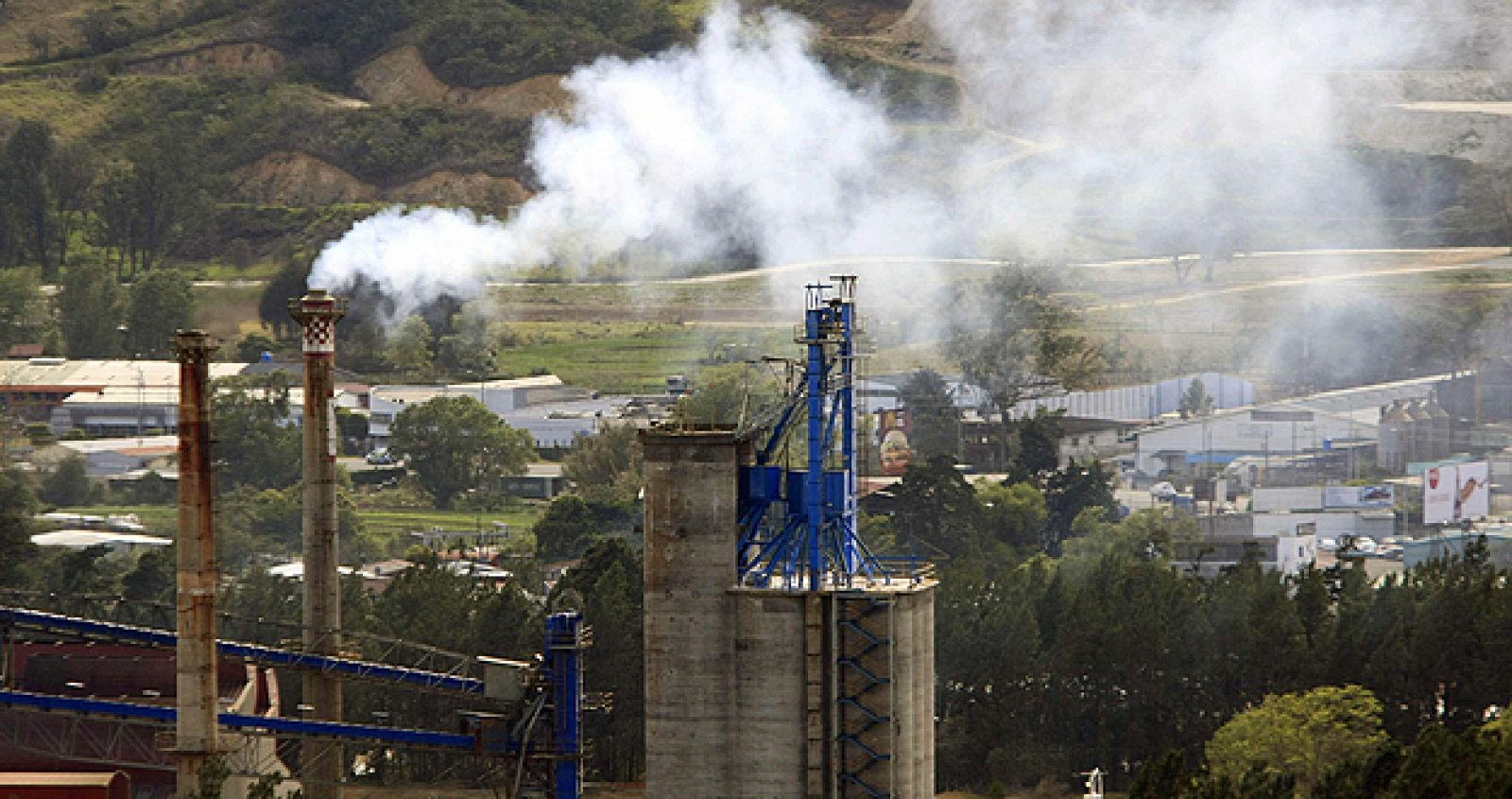 Una chimenea arroja humo en una zona industrial