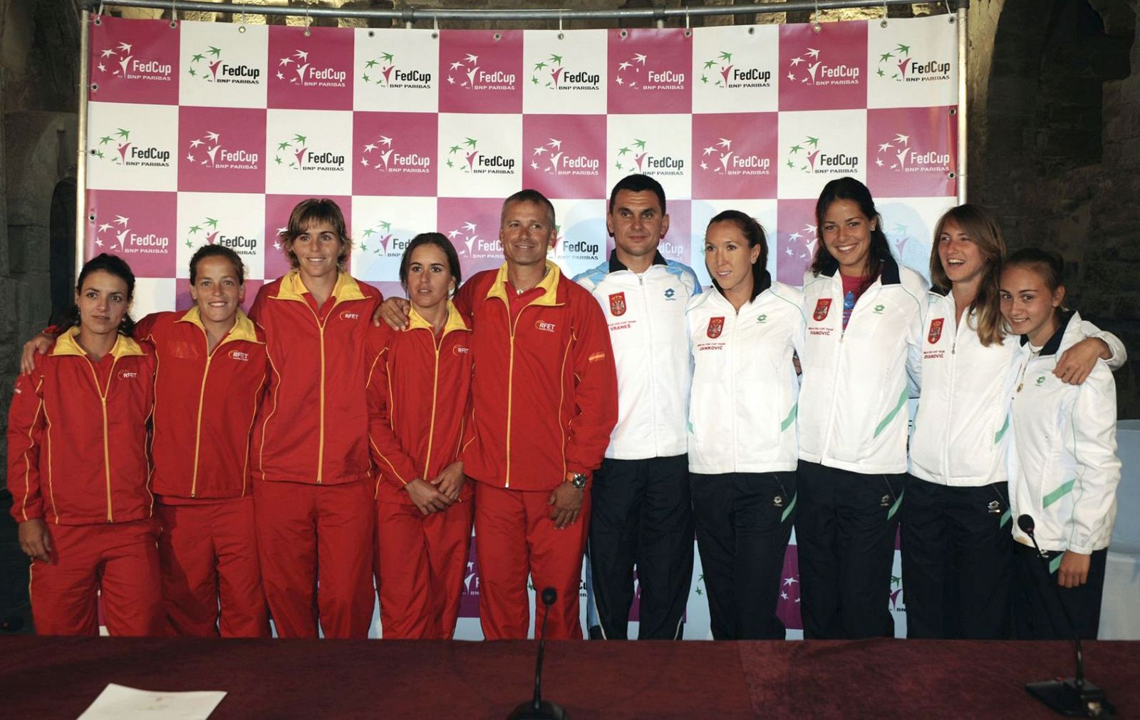 Las integrantes del equipo español junto a las del conjunto serbio durante el sorteo de la eliminatoria de Copa Federación, para la permanencia en el Grupo Mundial.