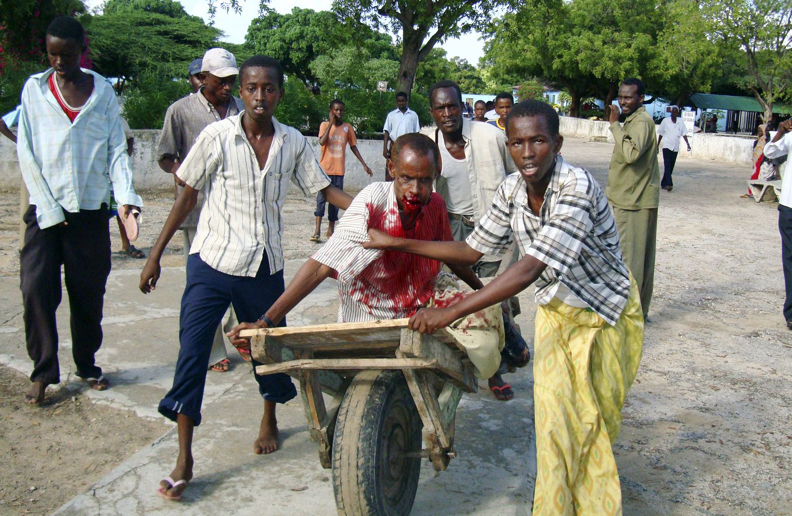 Un grupo de civiles empujan a un herido en el fuego cruzado en el capital de Somalia entre el ejército y las milicias islamistas.