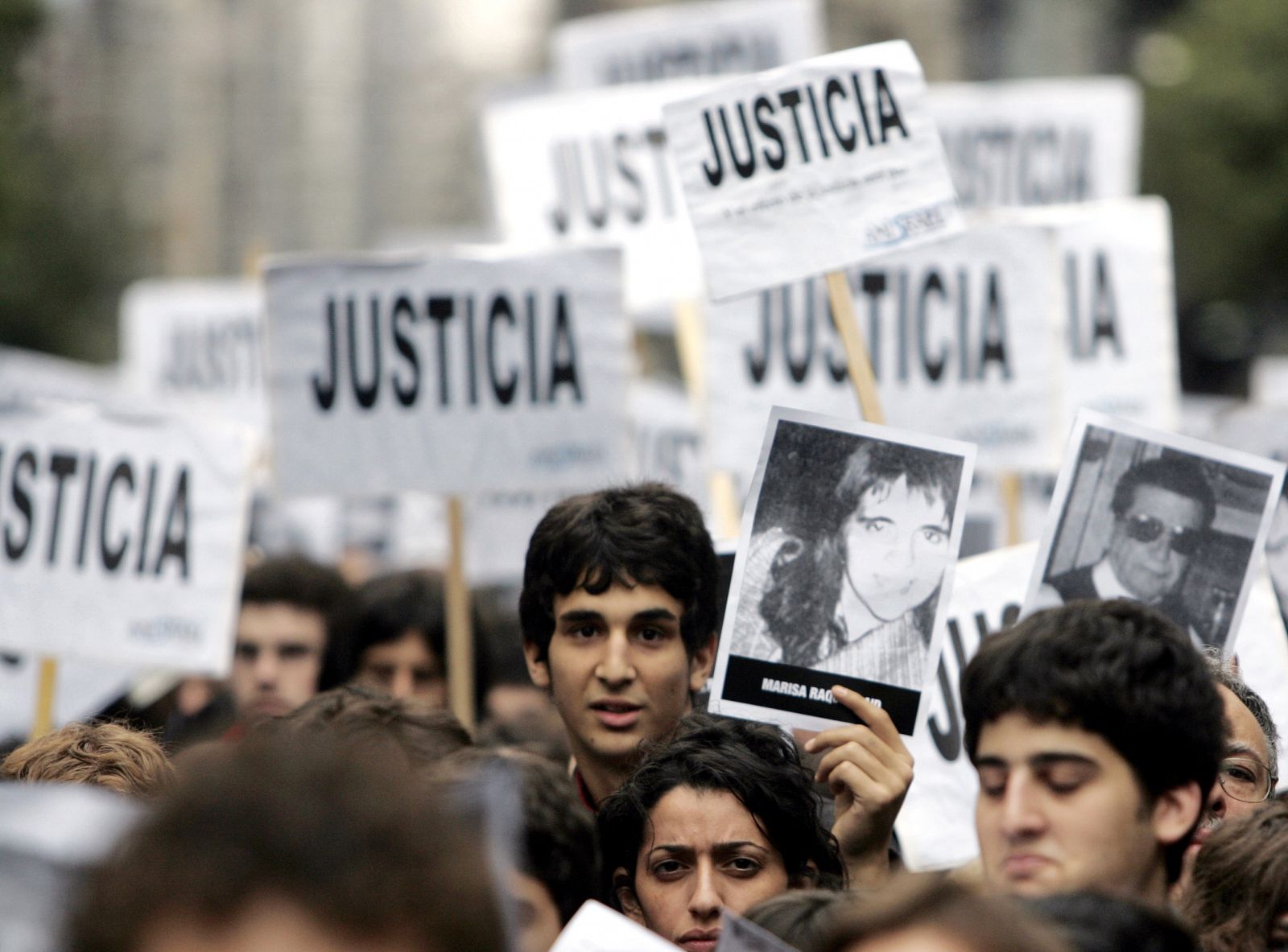 People hold pictures of their lost relatives during commemoration of anniversary of 1994 bombing of Jewish community center in Buenos Aires