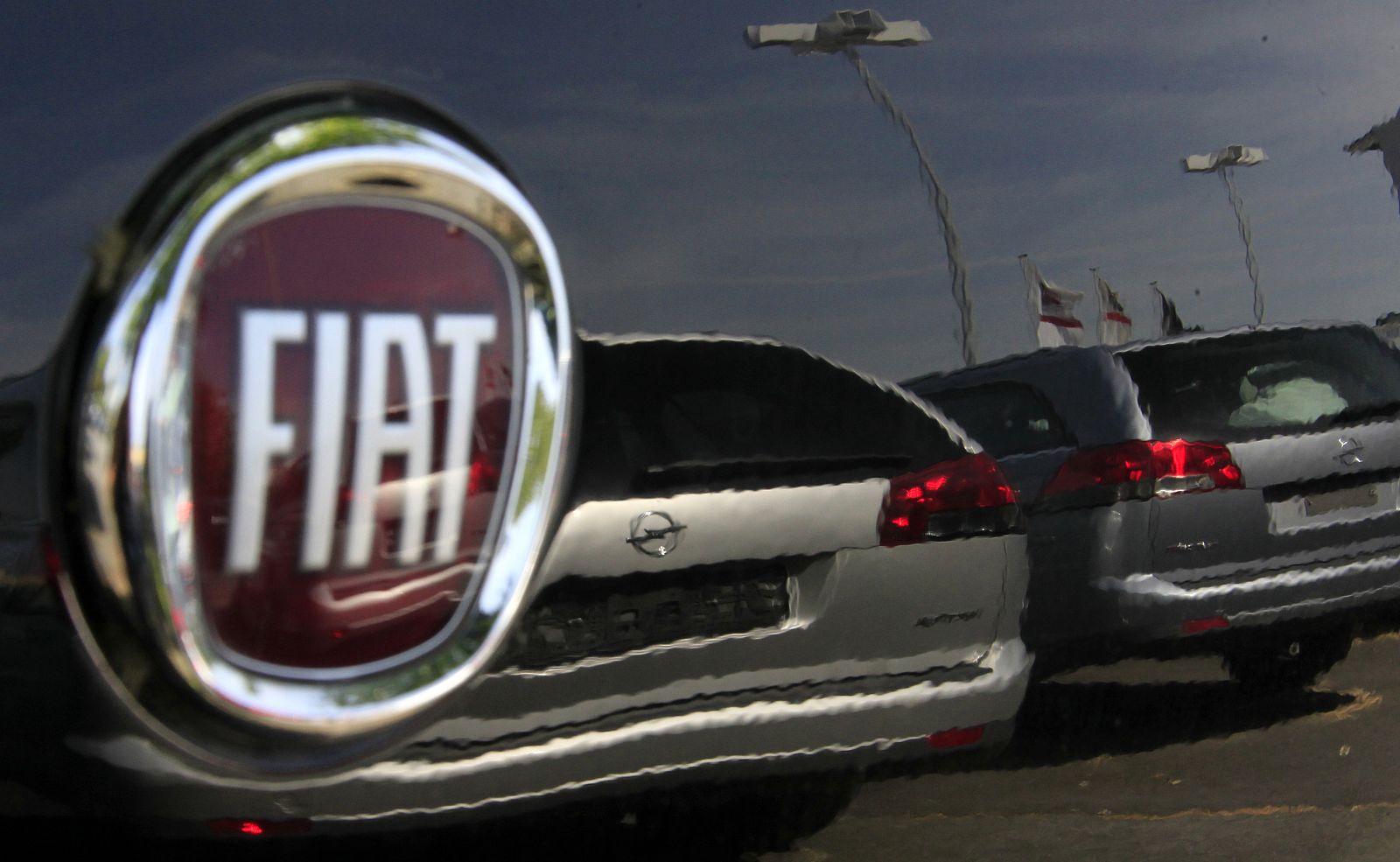 Two Opel cars are reflected in a Fiat car at a car seller in Darmstadt