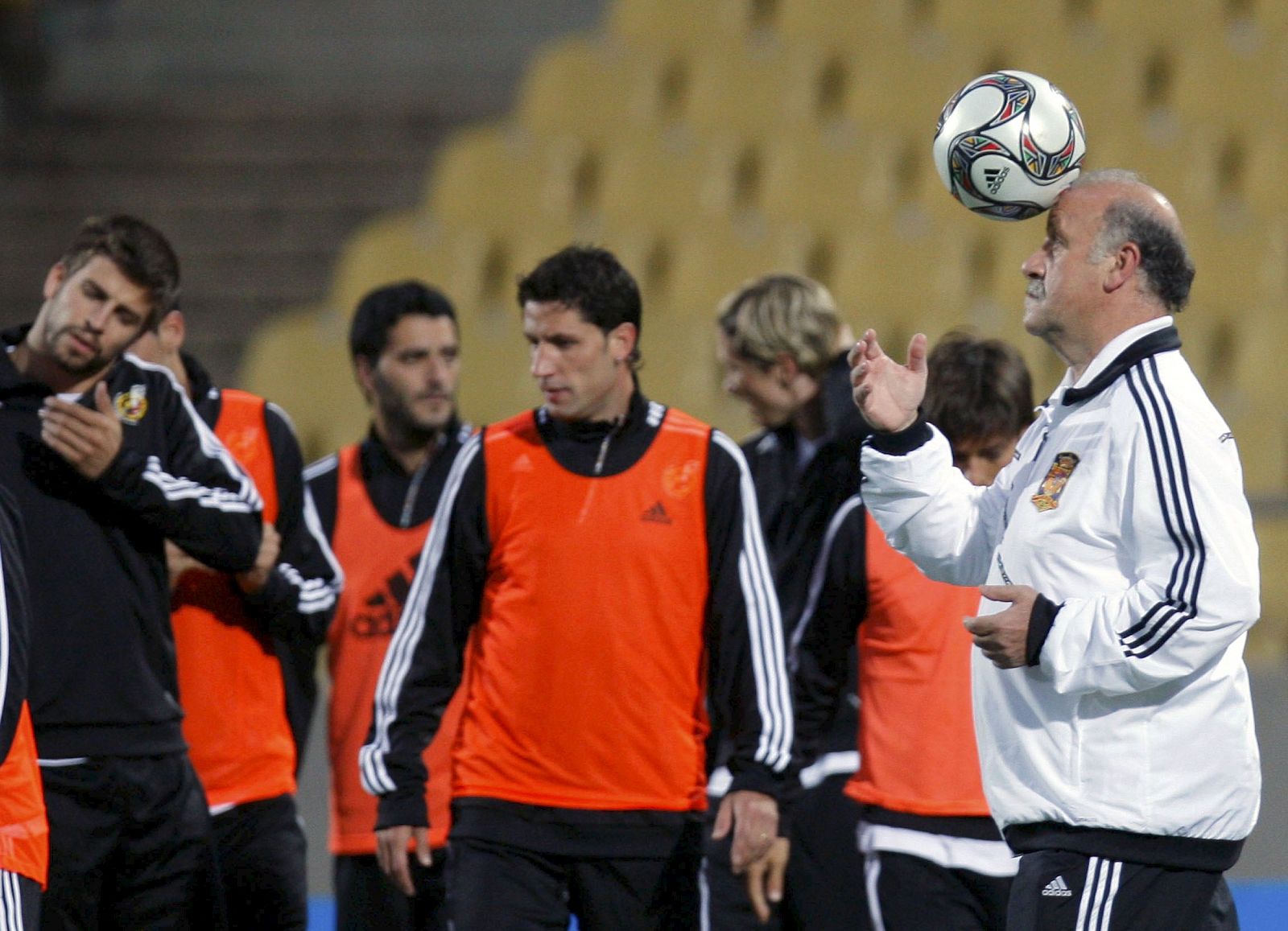 Vicente del Bosque, con la pelota, mientras sus jugadores entrenan