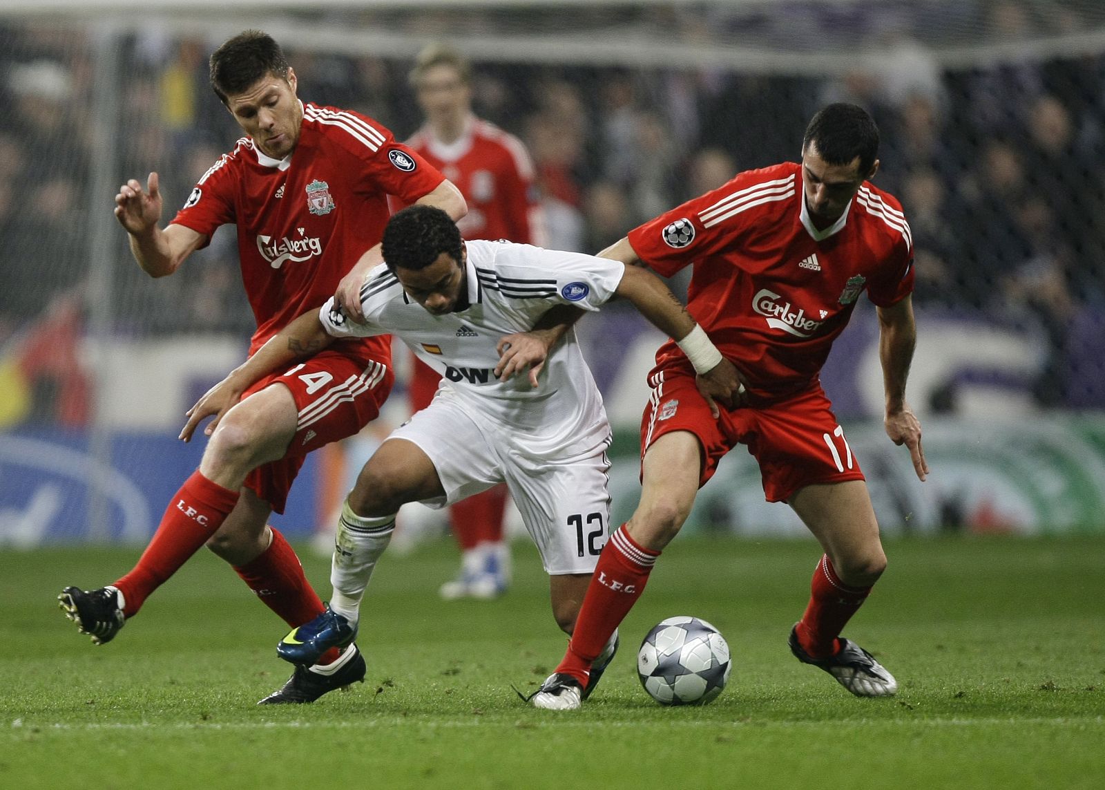 Xabi Alonso y Arbeloa pugnan por el balón contra el jugador del Real Madrid Marcelo.