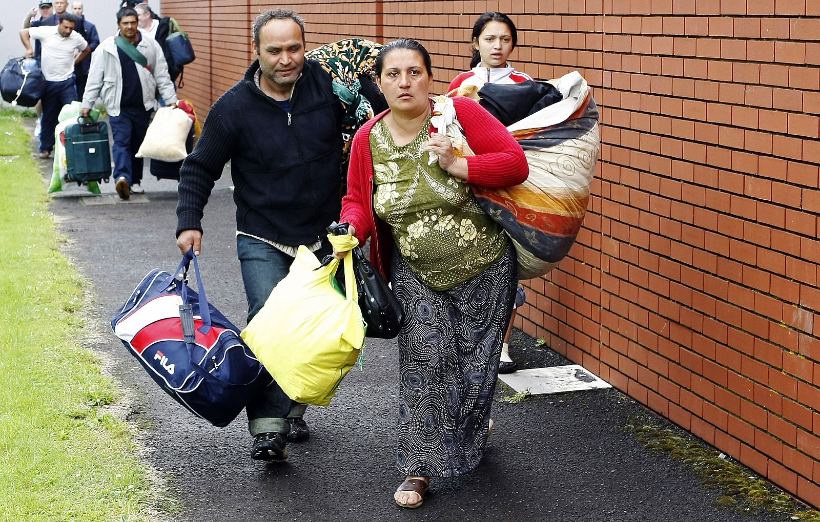 Romanians arrive with some of their possessions at the Ozone Leisure Centre in East Belfast