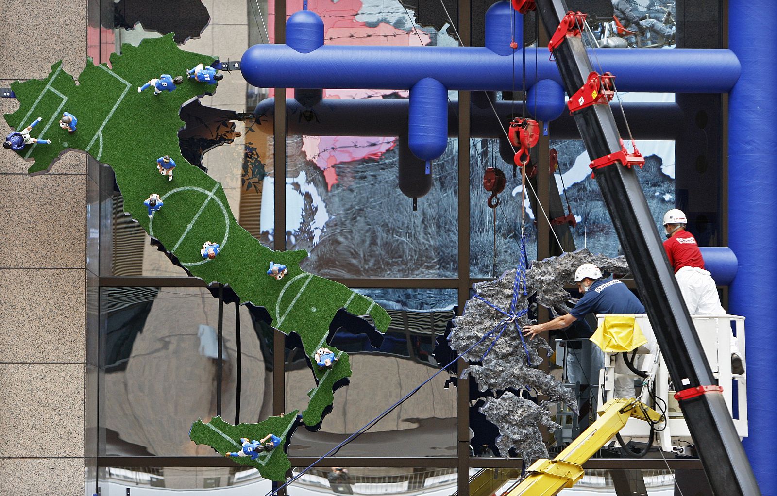 Trabajadores retiran una escultura realizada por el artista checo David Cerny en Bruselas.