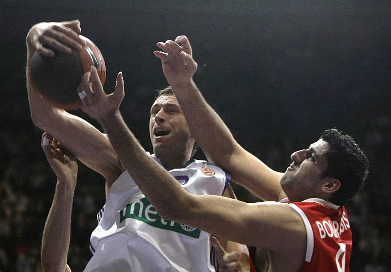 El jugador del Real Madrid, Tomas Van Den Spiegel lucha por la pelota con la marca del Iaonnis Bourousis del Olympiacos.