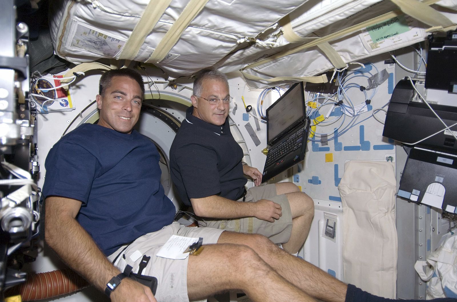 Los astronautas Christopher Cassidy (i) y Dave Wolf se  preparan para realizar la tercera caminata espacial