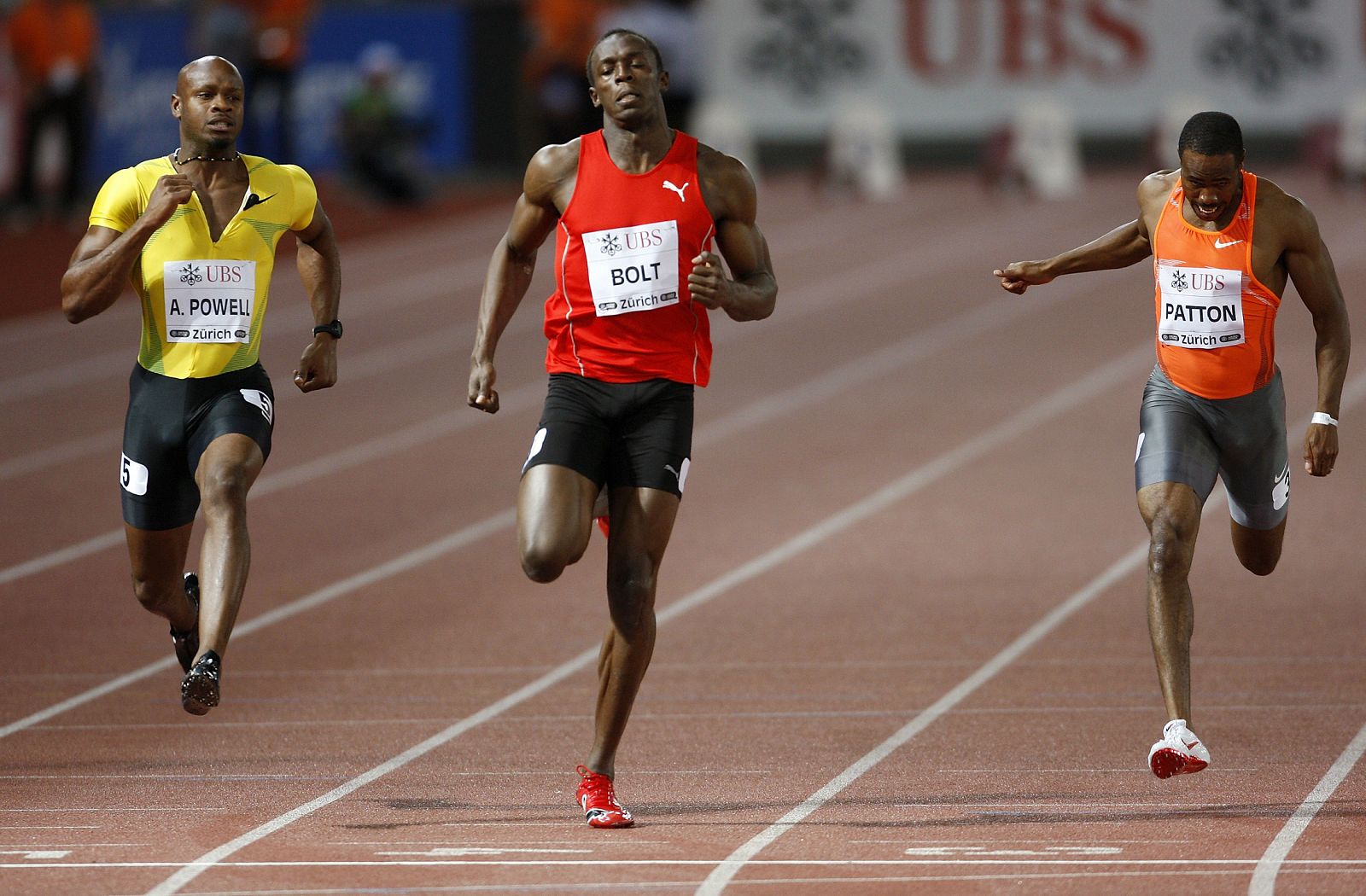 Bolt cruza la meta en Zúrich flanqueado por Asafa Powell y Darvis Patton