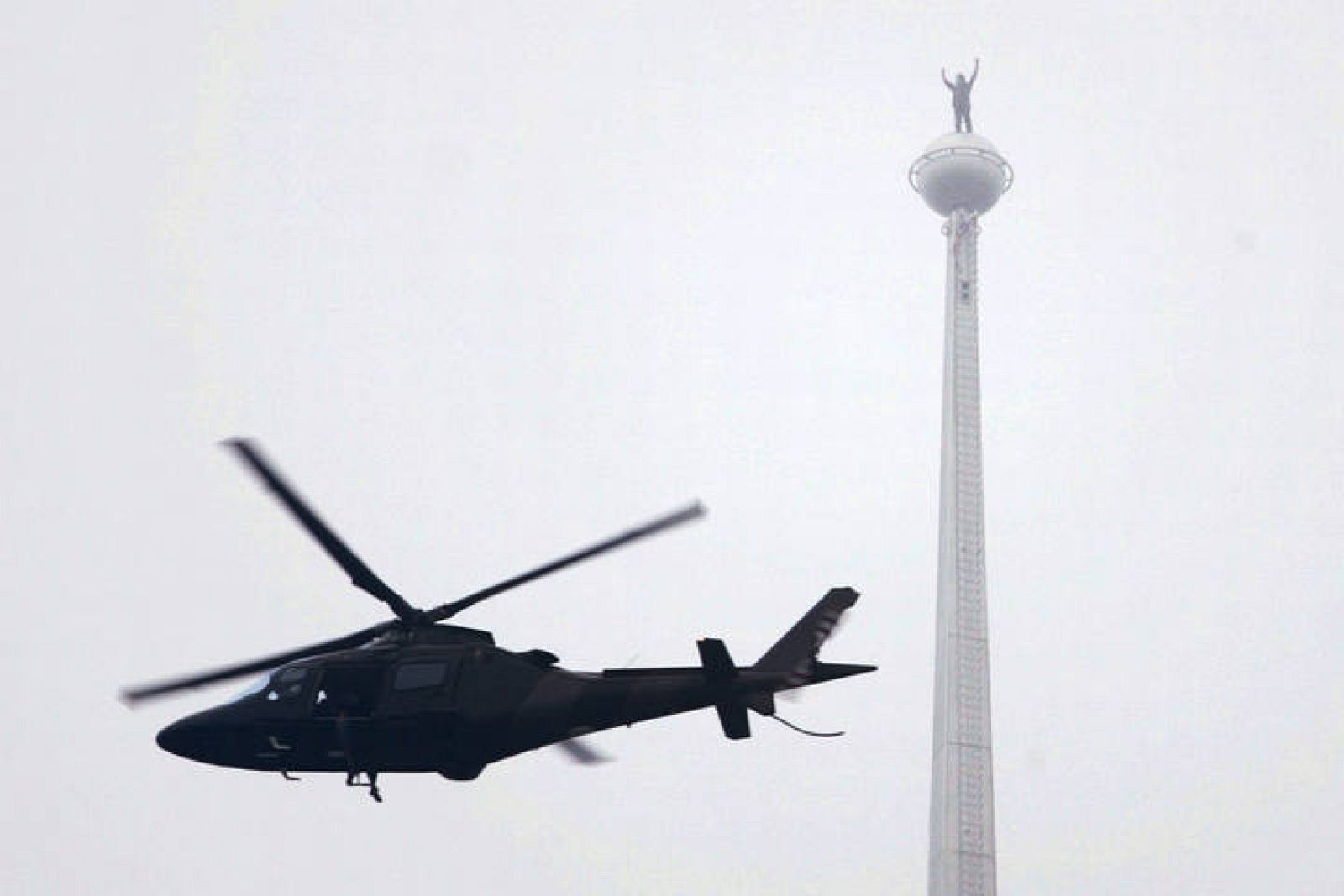 French climber Alain Robert, known as "Spiderman" stands on the tip of the Malaysia's landmark Petronas Twin Towers after scaling it, in Kuala Lumpur