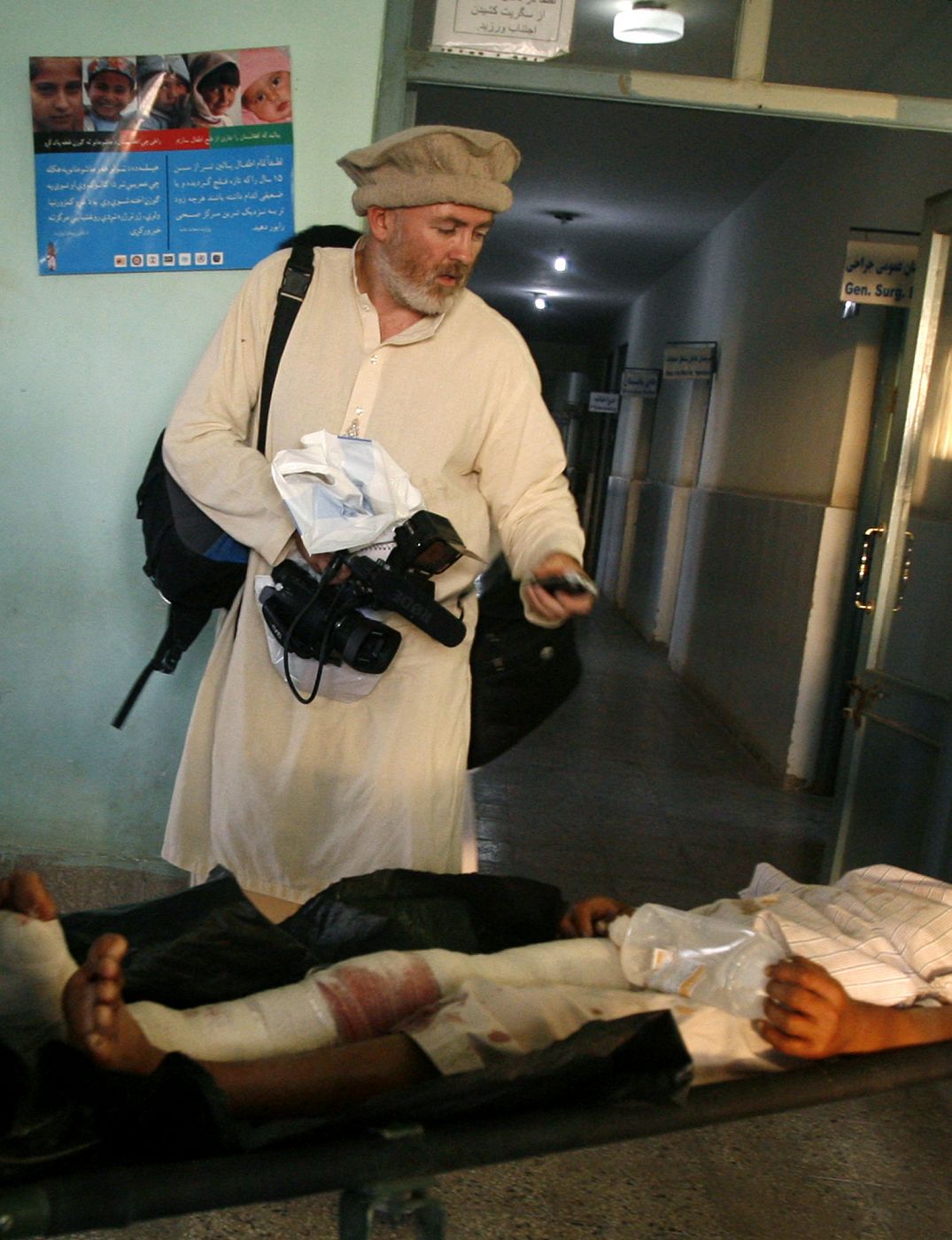 Stephen Farrell, British reporter for the New York Times, films a wounded Afghan man in a hospital in Kunduz