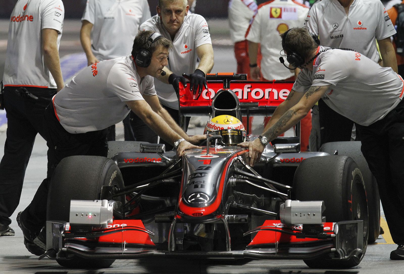 Mechanics push the car of McLaren Formula One driver Hamilton of Britain in pit lane during third practice session Singapore F1 Grand Prix at Marina Bay street circuit