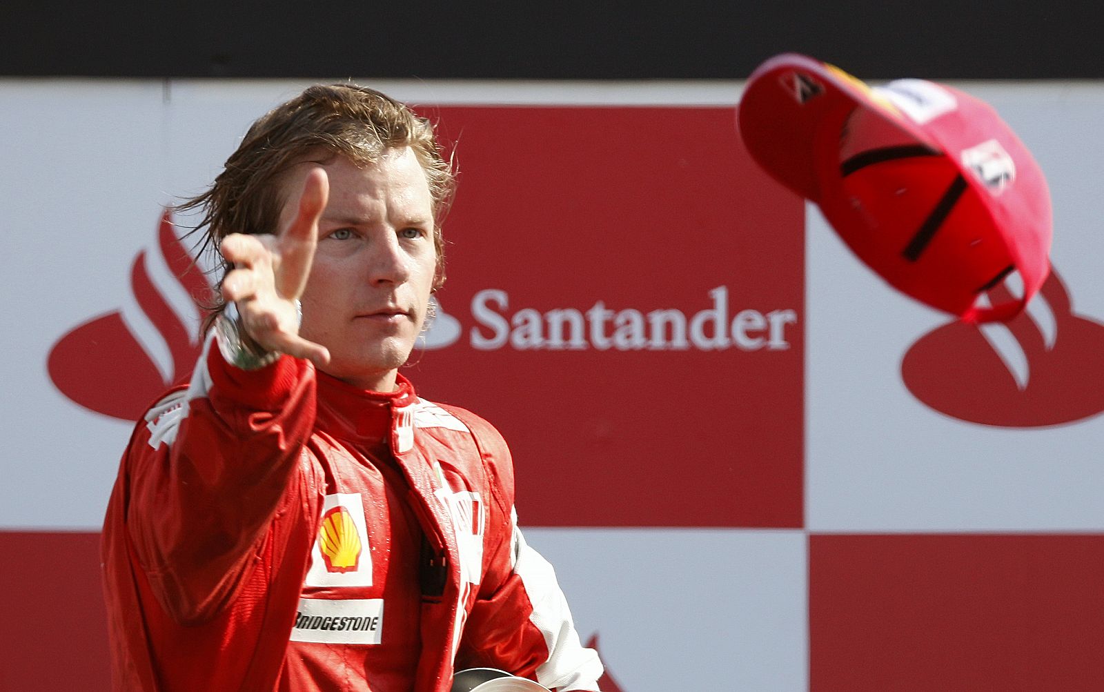 Ferrari Formula One driver Raikkonen of Finland throws his hat to the crowd after getting the third place in the Italian F1 Grand Prix in Monza