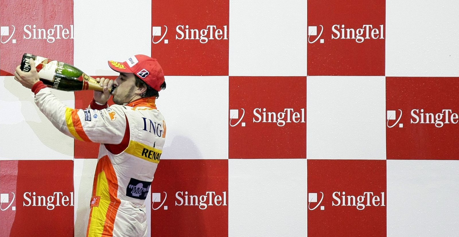 Fernando Alonso celebra con champán su tercer puesto en el GP de Singapur.