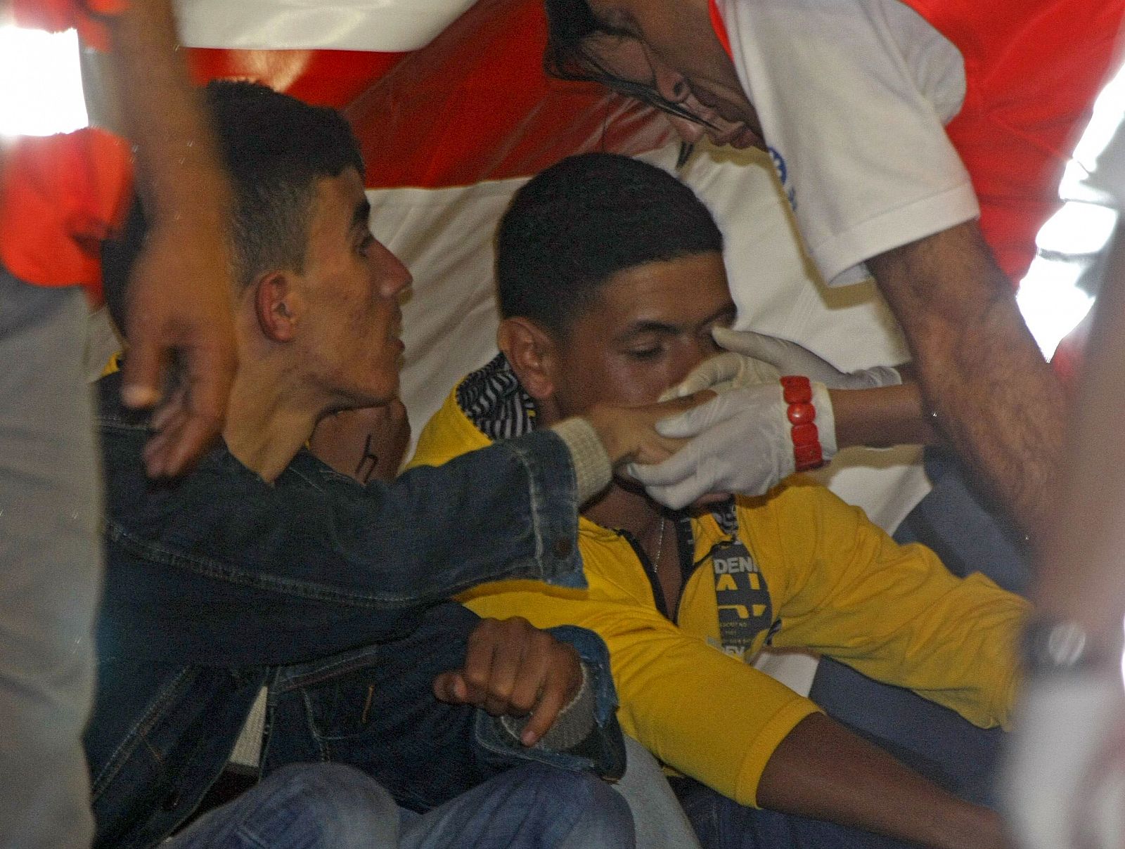 Miembros de la cruz roja asisten a los inmigrantes interceptados en una patera junto a isla de La Graciosa