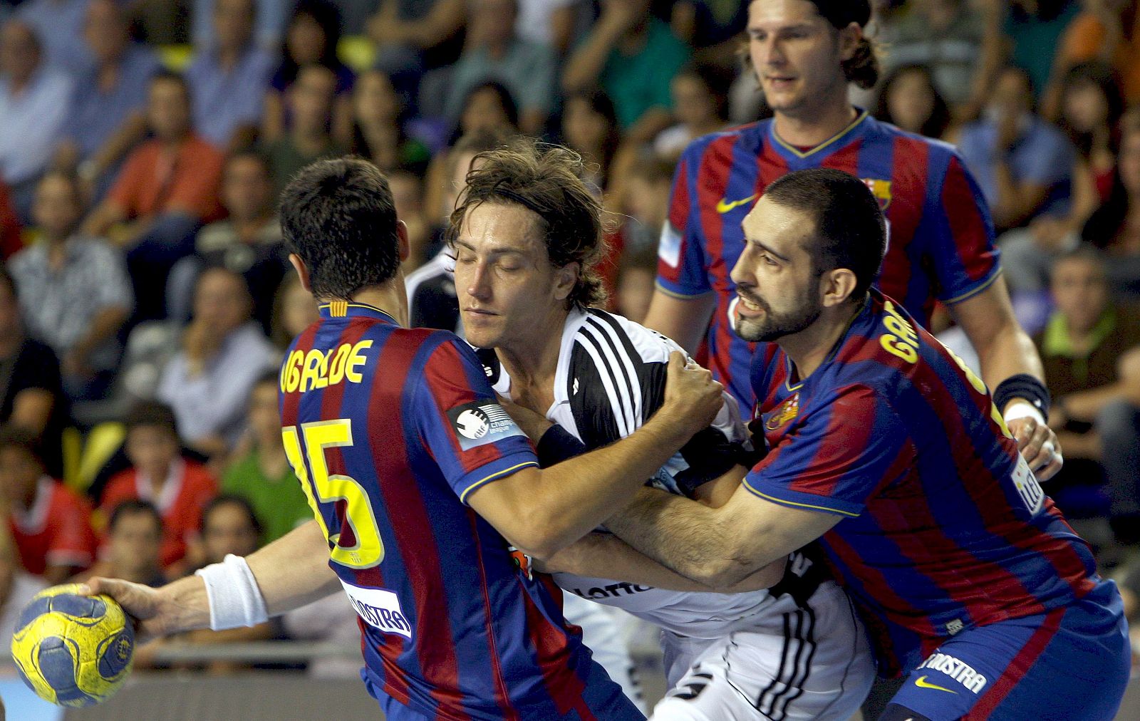 Marcus Ahlm, del Kiel, controla el balón ante el bloqueo de Ugalde y Garabaya.