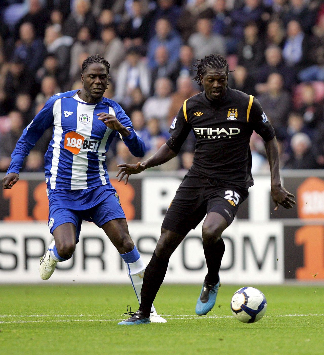 El delantero togolés del Manchester City Emmanuel Adebayor lucha por el balón con el holandés Mario Melchiot, del Wigan.