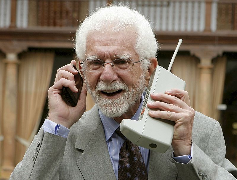 El ingeniero norteamericano Martin Cooper posa con dos modelos de teléfono móvil en Oviedo donde recogerá el premio Príncipe de Asturias.