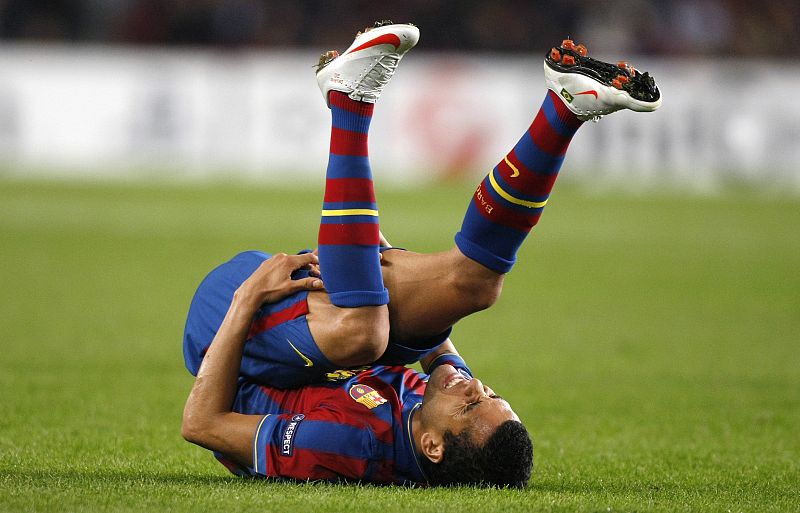 Barcelona's Dani Alves grimaces after being tackled by a Rubin Kazan player during their Champions League soccer match at the Camp Nou stadium in Barcelona
