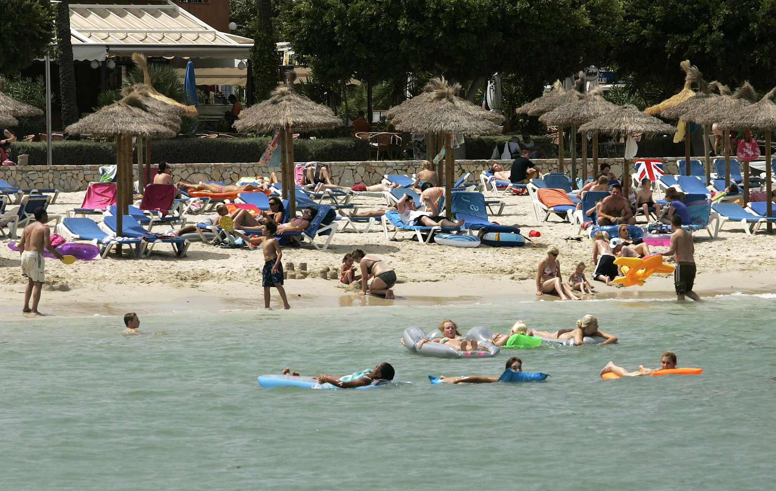 Un grupo de turistas se relaja en la playa en Mallorca
